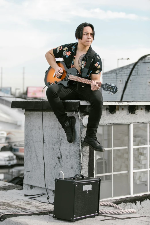 a man sitting on top of a building with a guitar, non binary model, cindy avelino, standing on a rooftop, octane fender