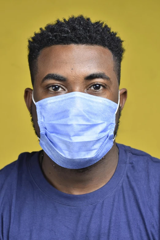 a man wearing a face mask against a yellow background, by Everett Warner, david uzochukwu, young male, surgery, on grey background