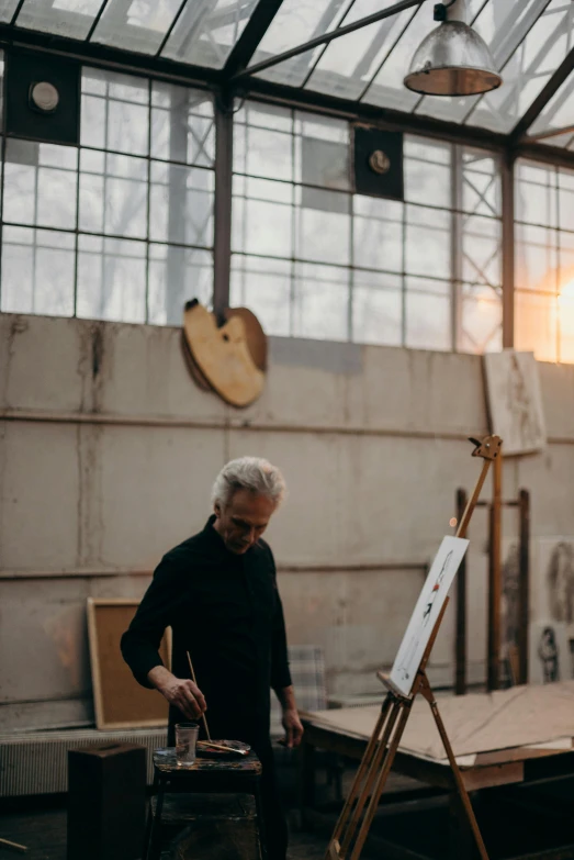 a man that is standing in front of a easel, during golden hour, jimmy page, in a workshop, jovana rikalo