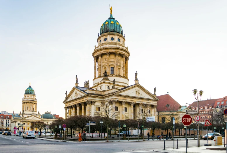 a large building sitting on the side of a road, pexels contest winner, berlin secession, neoclassical tower with dome, berkerk, baroque winding cobbled streets, profile image