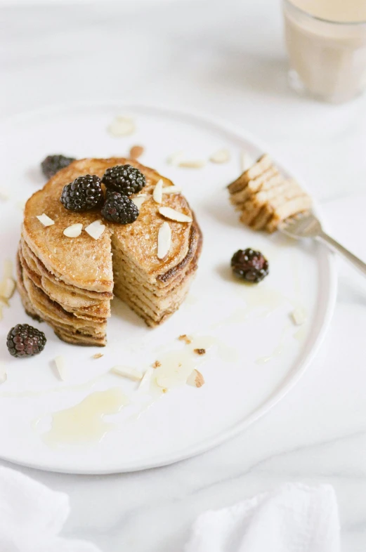 a stack of pancakes sitting on top of a white plate, a portrait, unsplash, arper's bazaar, seeds, “berries, blond