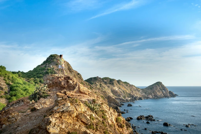 a man standing on top of a mountain next to the ocean, pexels contest winner, process art, ibiza, vietnam, thumbnail, gigapixel photo