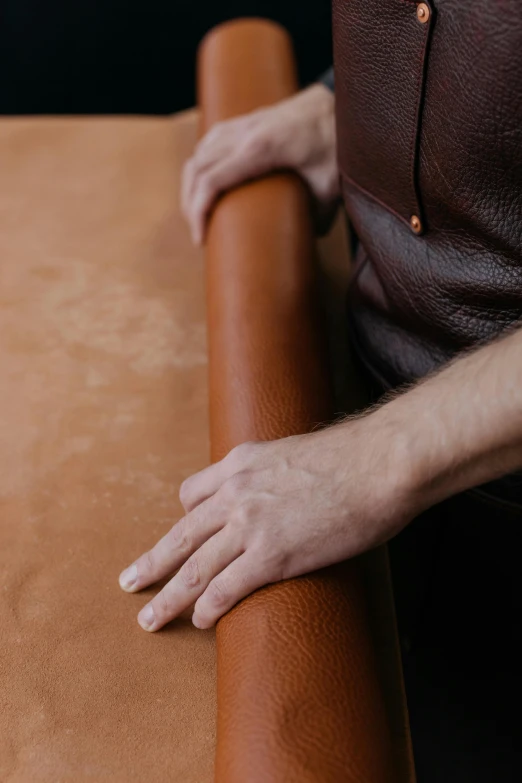 a close up of a person holding a roll of leather, bench, cinnamon skin color, smooth contours, kneeling