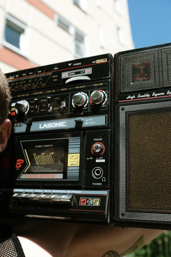 a close up of a person holding a radio, by Lee Loughridge, trending on unsplash, graffiti, massive 7 0 s hi fi system, giant speakers, 15081959 21121991 01012000 4k, charts