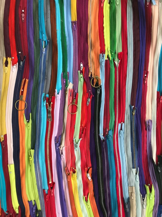 a wall filled with lots of different colored zippers, by Terese Nielsen, shot on iphone, close-up photograph, colorful acrylic, multi - coloured
