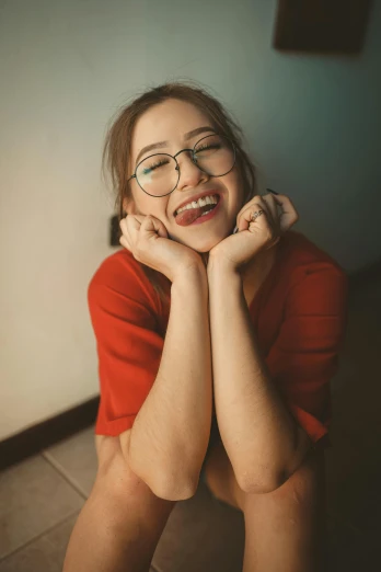 a woman with glasses sitting on the floor, trending on pexels, underbite, wearing a red outfit, happy girl, russian girlfriend