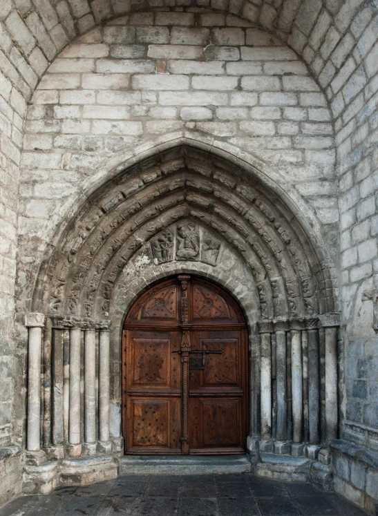 a large stone building with a wooden door, inspired by Barthélemy d'Eyck, unsplash, romanesque, grey, square, vault, chamonix