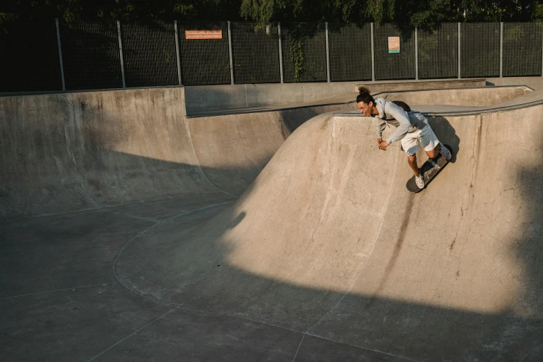 a man riding a skateboard up the side of a ramp, a picture, isabela moner, smooth solid concrete, at a park, jovana rikalo