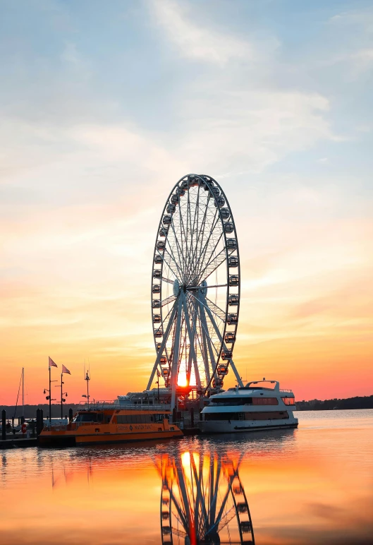 a ferris wheel sitting next to a body of water, by Washington Allston, during a sunset, during the day, evening time, wide views