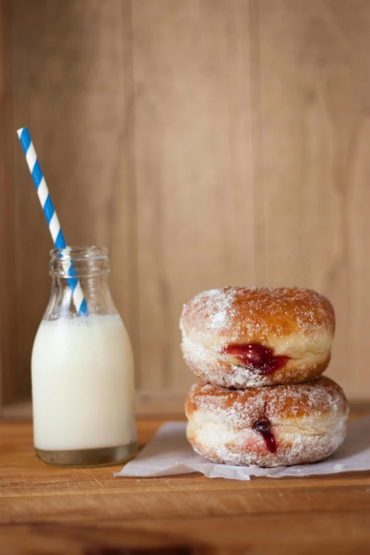 a couple of doughnuts sitting next to a glass of milk, crimson, square, f/8.0, organics