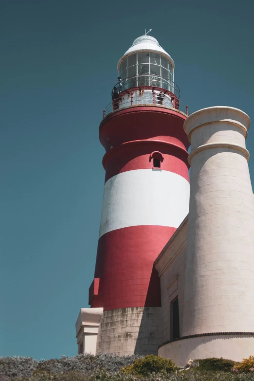 a red and white lighthouse sitting on top of a hill, buttresses, mint higlights, farol da barra, up-close