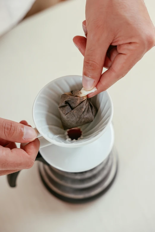 a close up of a person putting something in a cup, by Yasushi Sugiyama, degradation filter, grey, arabica style, datura