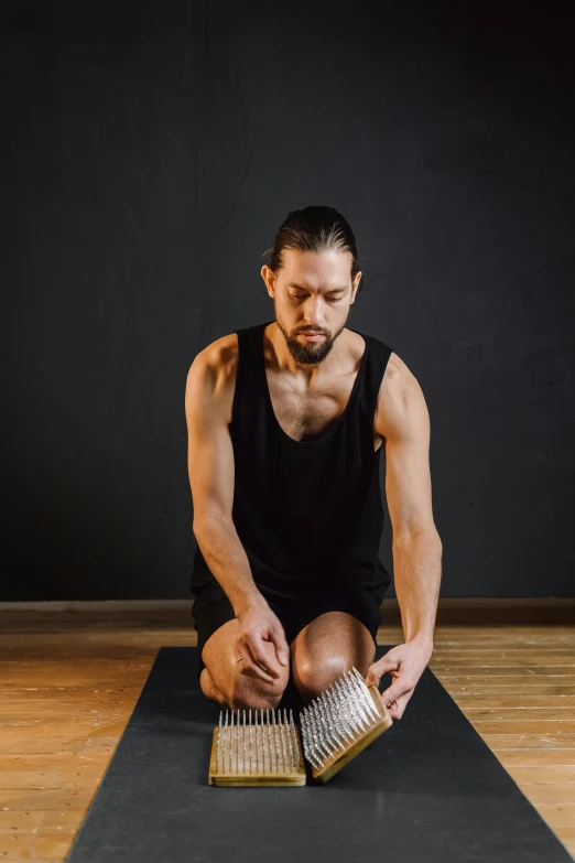 a man sitting on top of a yoga mat, an album cover, pexels contest winner, renaissance, acupuncture treatment, musculature, chainmail, no - text no - logo