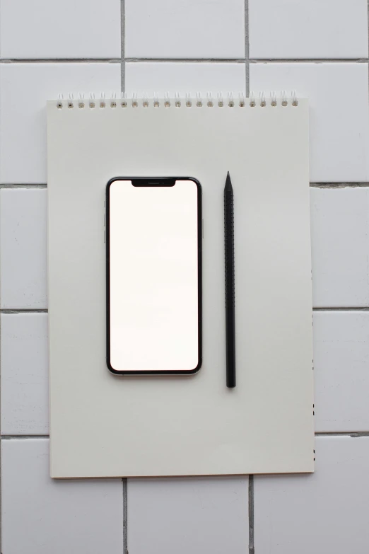 a cell phone sitting on top of a notepad next to a pencil, a minimalist painting, trending on pexels, minimalism, whiteboards, professional iphone photo, square, white and black