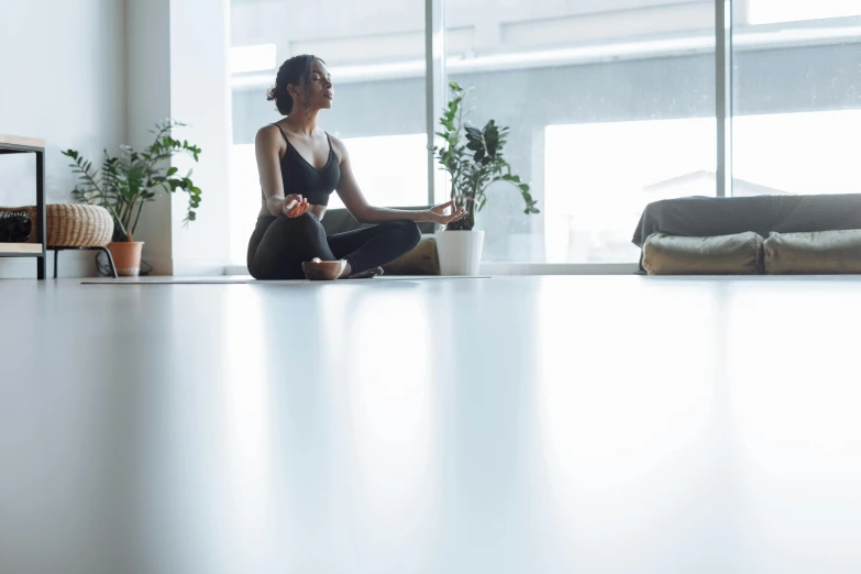 a woman sitting on the floor in a yoga pose, unsplash, light and space, sitting in a waiting room, profile image, city views, on a table