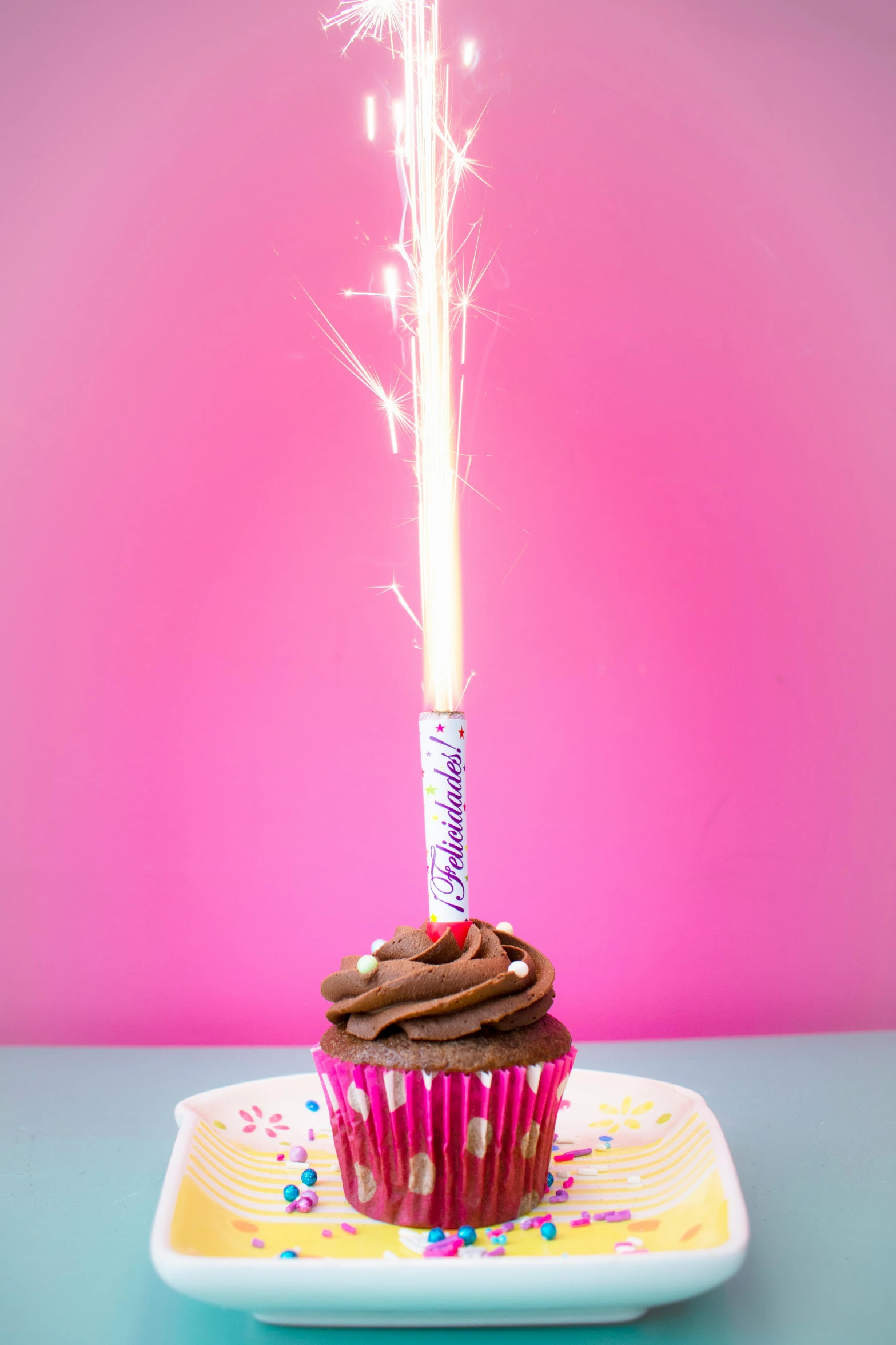 a cupcake with a sparkler on top of it, on a candle holder, adafruit, bubblegum pop, chocolate frosting