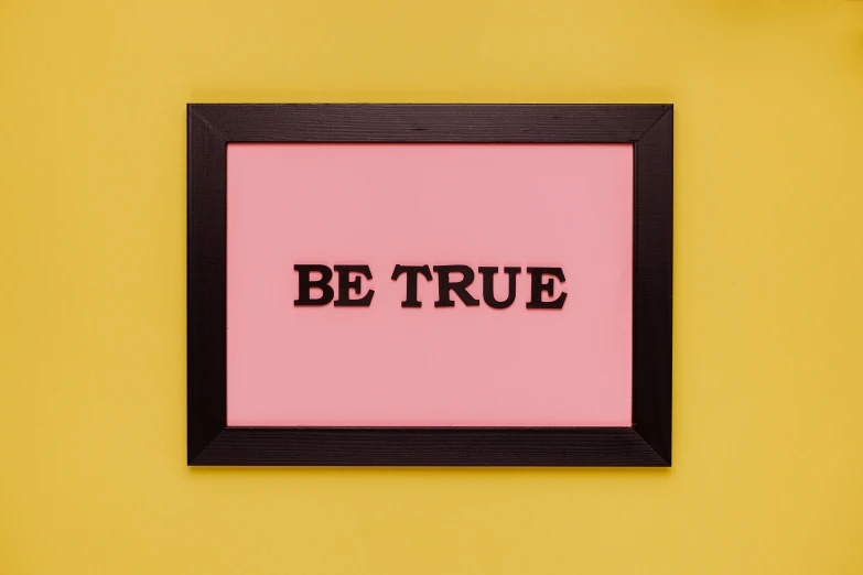 a picture frame with the word be true on it, by Julia Pishtar, unsplash, international typographic style, pink and yellow, pink and black, pub sign, studio picture
