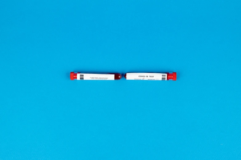 a pen sitting on top of a blue surface, medical labels, red color bleed, 3 5 mm lomography, one on each side