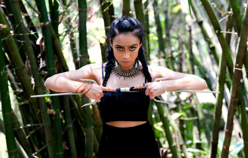 a woman in a black dress holding two swords, pexels contest winner, sumatraism, wearing a crop top, avatar image, jungle, black jewellery