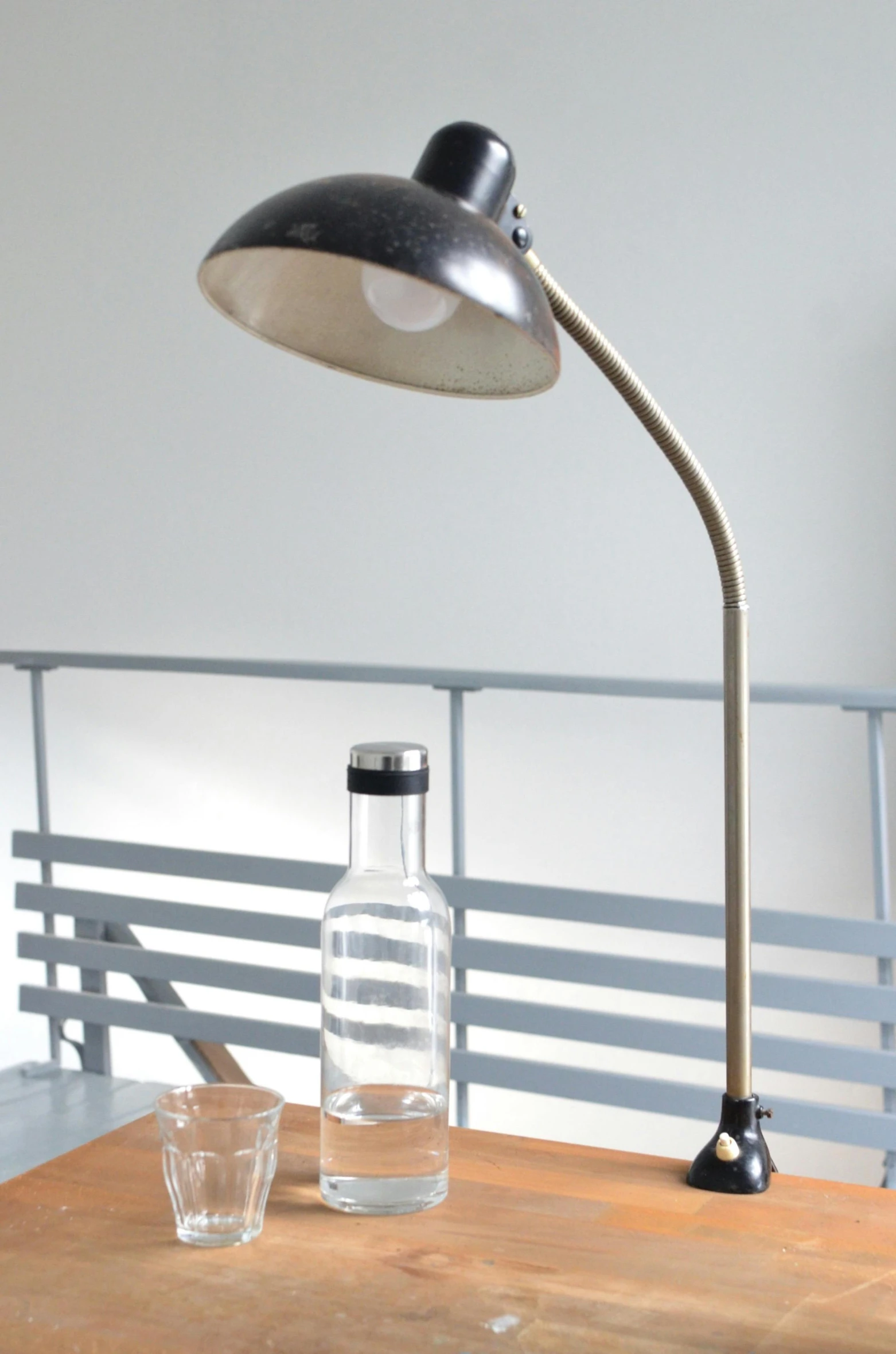 a desk lamp sitting on top of a wooden table, by Haukur Halldórsson, drinking, vintage style, worn, displayed