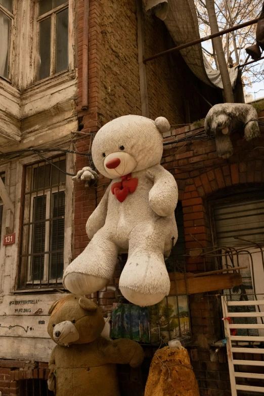 a white teddy bear sitting on top of a pile of stuffed animals, an album cover, by Filip Hodas, graffiti, dilapidated houses, kreuzberg, balloon, ignant