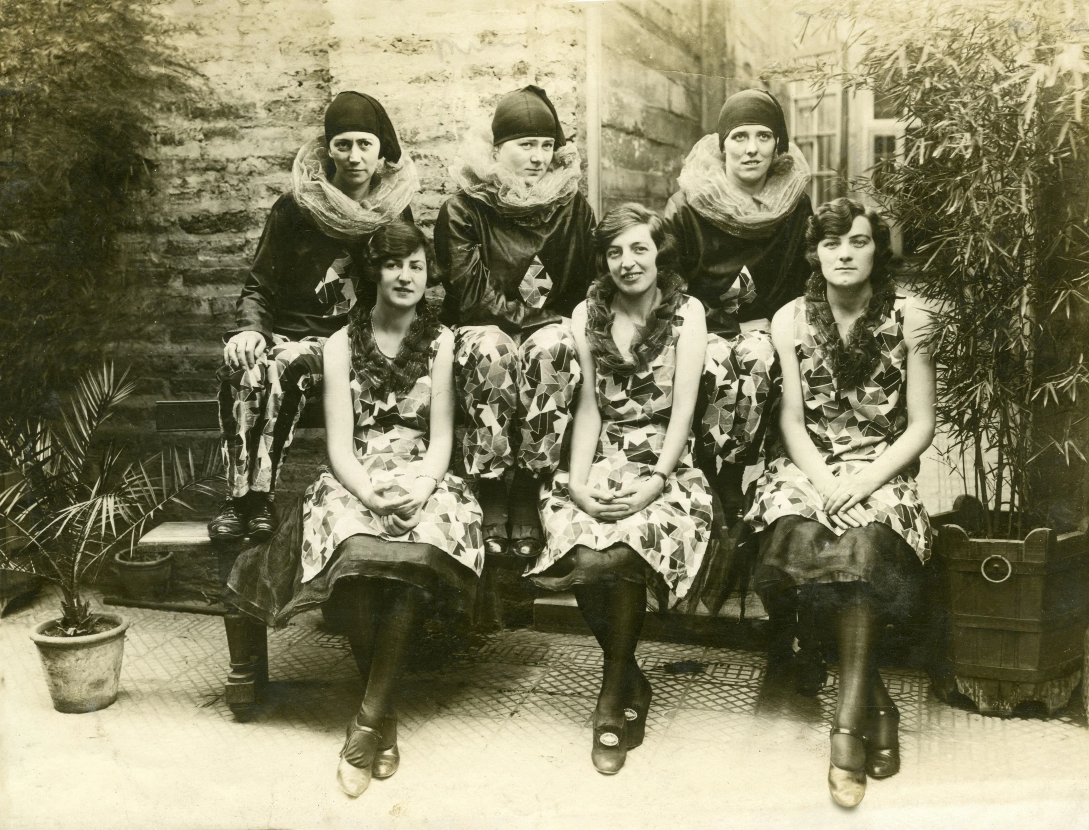 a group of women sitting next to each other, a black and white photo, art nouveau, wearing festive clothing, sports photo, vintage associated press photo, promotional image