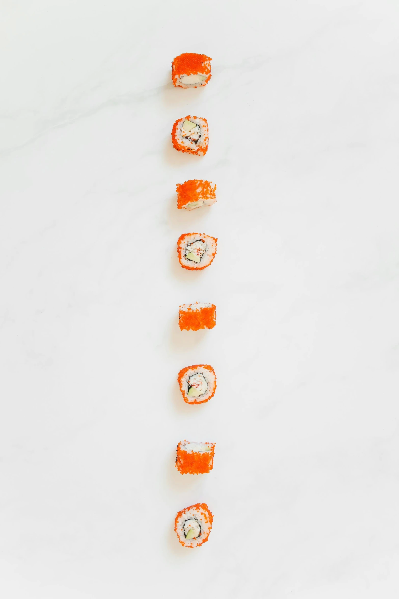 a row of sushi sitting on top of a white counter, inspired by Tōshi Yoshida, unsplash, conceptual art, orange, ffffound, flatlay, spiraling