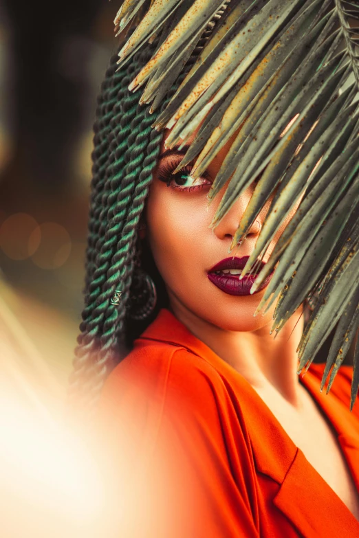 a woman holding a palm leaf in front of her face, an album cover, by Adam Marczyński, trending on pexels, afrofuturism, thick red lips, 5 0 0 px models, somali woman, at a fashion shoot