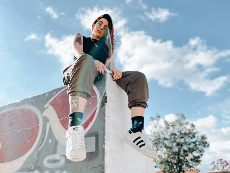 a man riding a skateboard up the side of a ramp, by Emma Andijewska, trending on pexels, graffiti, powerful woman sitting in space, striped socks, avatar image, shaved sides