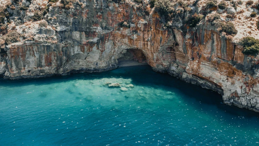 a large body of water next to a cliff, pexels contest winner, hurufiyya, greek pool, lachlan bailey, deep colour, thumbnail