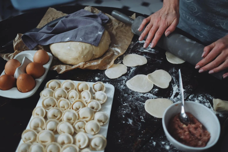 a close up of a person making food on a table, by Emma Andijewska, fan favorite, crispy buns, pasta, lifestyle