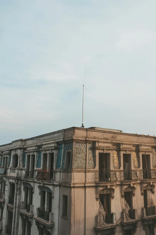 a tall building with a clock on top of it, inspired by Zhang Kechun, trending on unsplash, bengal school of art, an old abandoned mansion, shot from roofline, “wide shot, late morning