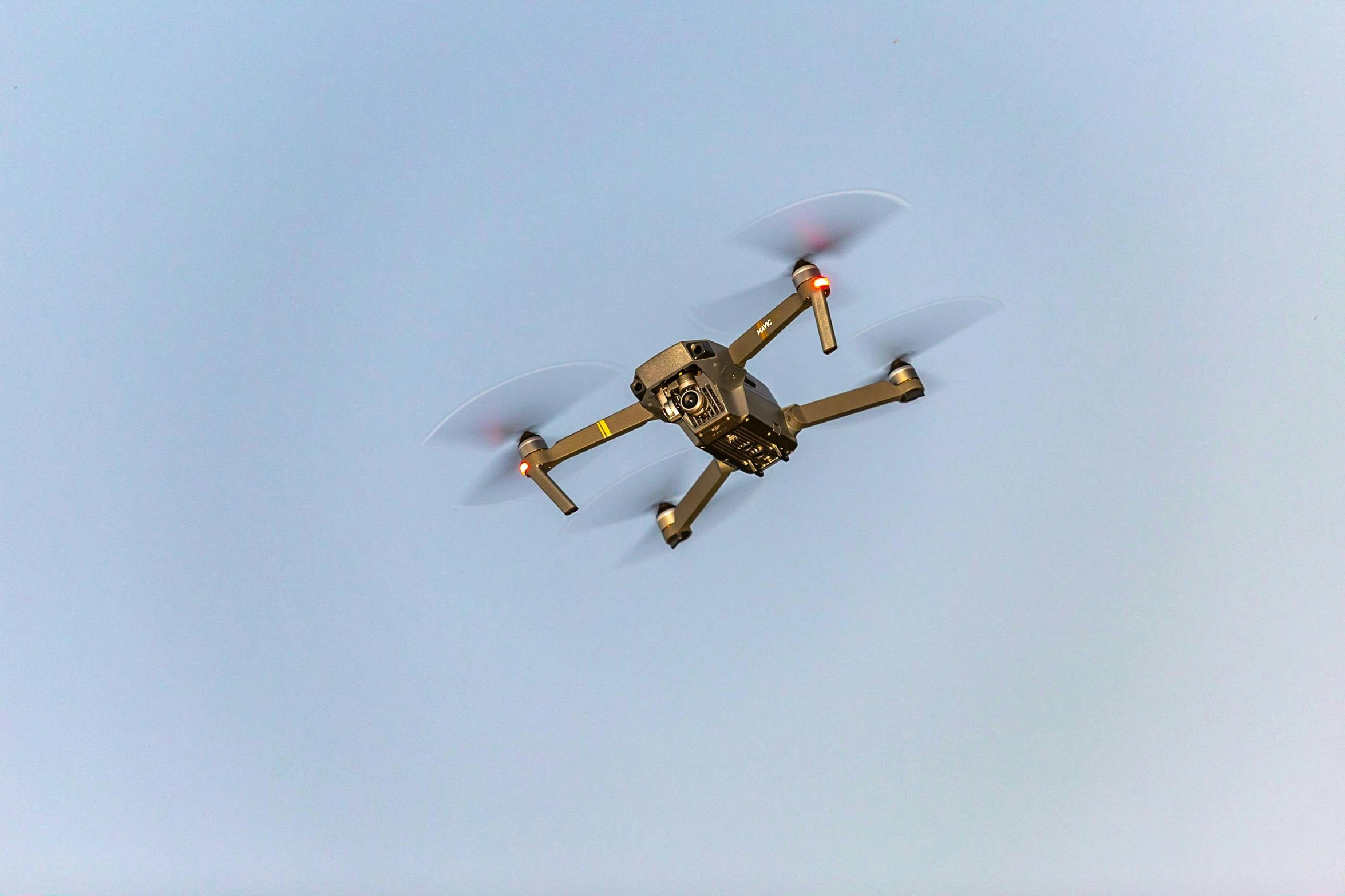 a small propeller plane flying through a blue sky, by Matthias Stom, pexels, renaissance, police drones, brown, gold, 2 0 0 0's photo