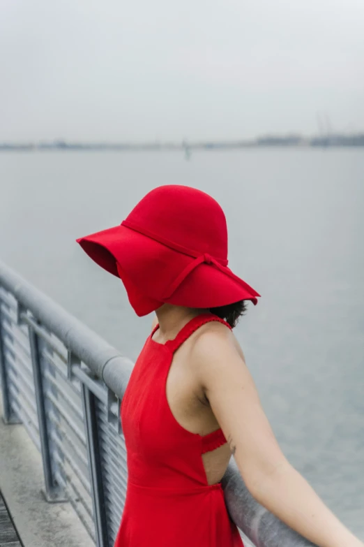 a woman in a red dress and a red hat, inspired by Ren Hang, unsplash, at the waterside, tricorne hat, felt, product shot