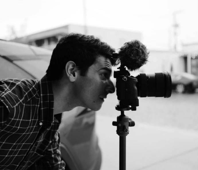 a man taking a picture with a camera, a black and white photo, by Ryan Pancoast, nathan fielder, performing a music video, halfbody headshot, candid portrait photograph