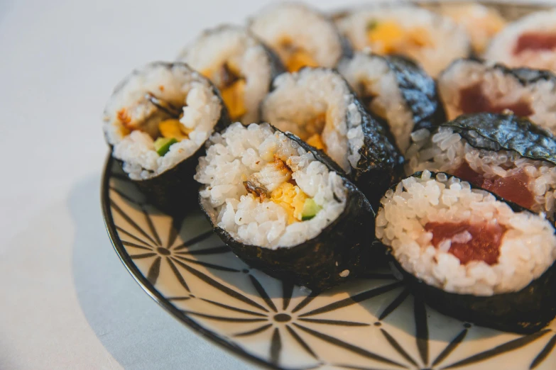 a plate of sushi sitting on a table, inspired by Maki Haku, unsplash, mingei, balls of rice, thumbnail, foil, brown