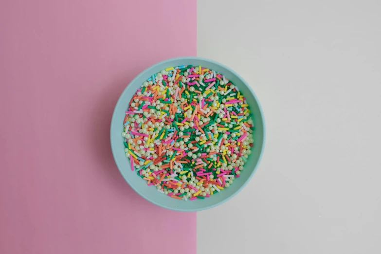 a bowl of sprinkles on a pink and white background, by Emma Andijewska, trending on unsplash, color field, turquoise pink and green, on a plate, accurate depiction, on a gray background