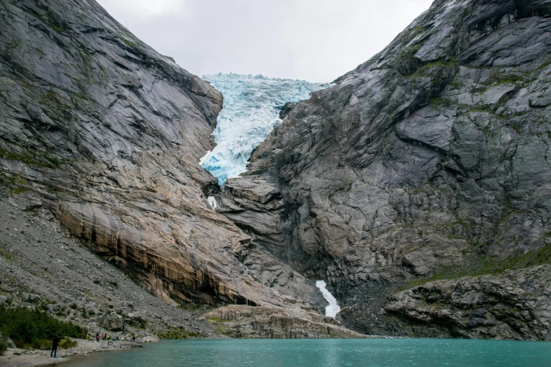 a group of people standing on top of a mountain next to a body of water, by Jesper Knudsen, pexels contest winner, hurufiyya, ice gate, landslides, the photo was taken from a boat, the entrance of valhalla