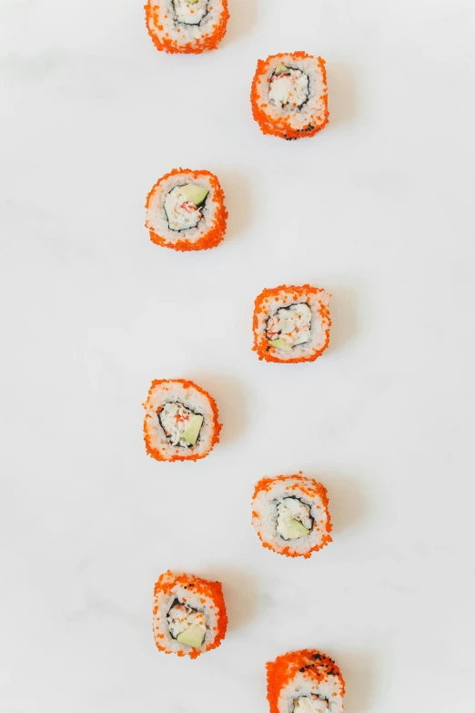 a white plate topped with lots of sushi, inspired by Maki Haku, unsplash, mingei, orange fluffy spines, 6 pack, epicurious, pale red