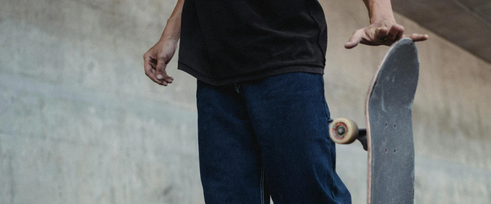 a man riding a skateboard up the side of a ramp, trending on pexels, realism, baggy jeans, wearing a navy blue utility cap, very grainy image, contemplating