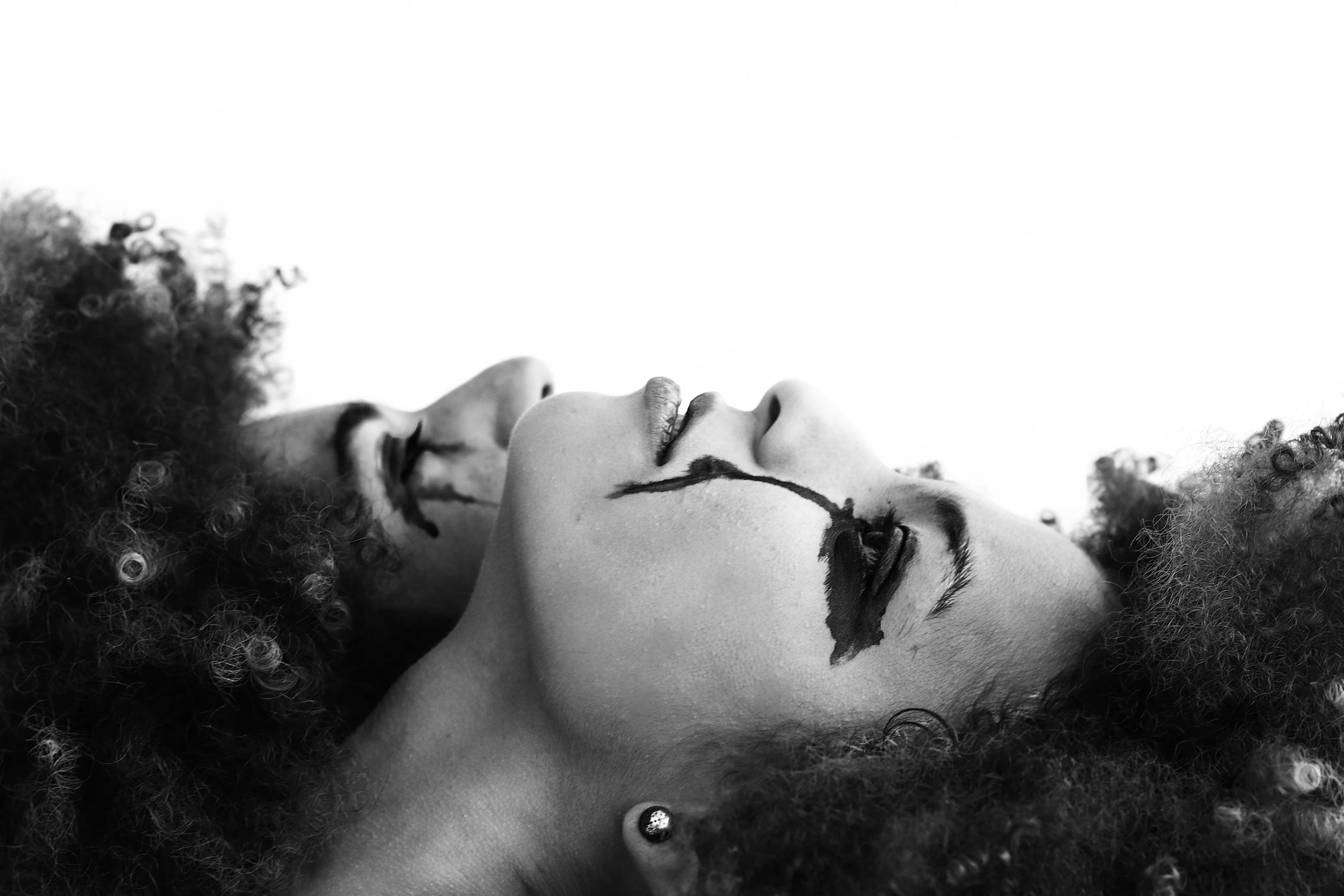 a black and white photo of a woman with curly hair, a black and white photo, pexels, art photography, siamese twins, blood around the lips, upsidedown, black black black woman