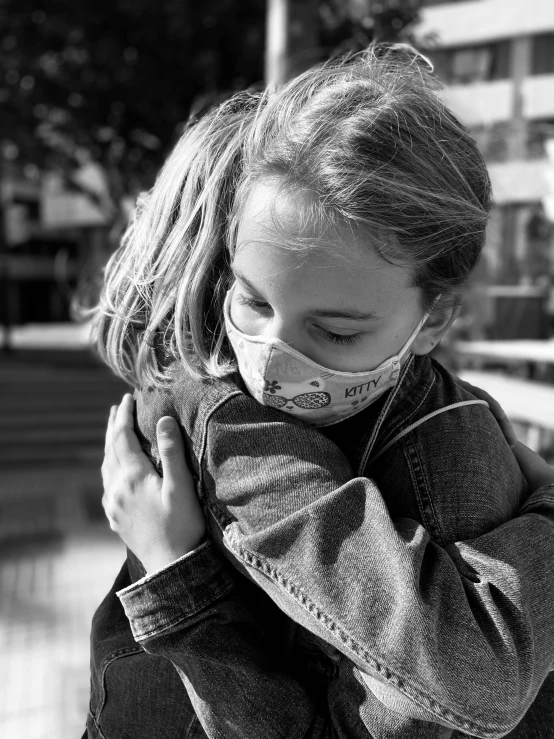 a black and white photo of a little girl wearing a face mask, a black and white photo, pexels, hugging each other, square, covid, profile pic