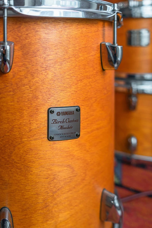 a group of drums sitting on top of a wooden floor, label, studio orange, detailed product image, detail shots