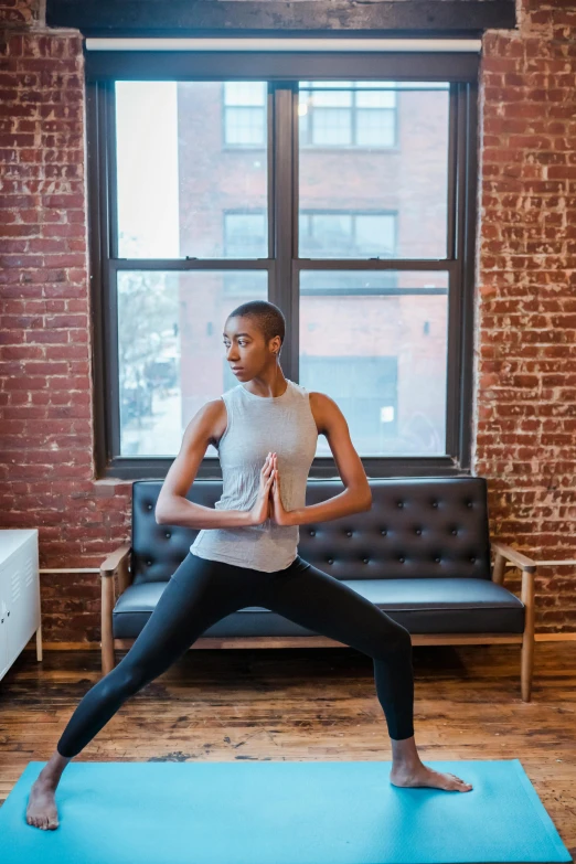 a man standing on a yoga mat in a living room, by Carey Morris, trending on unsplash, jamel shabazz, hero pose, promo image, doing splits and stretching