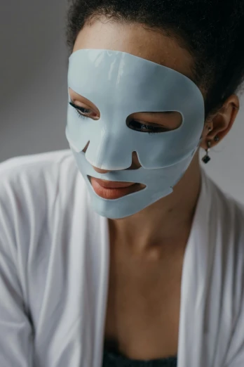 a woman with a blue mask on her face, soft face features, silicone skin, white porcelain skin, product shot