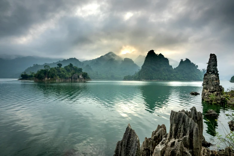 a large body of water with mountains in the background, inspired by Pierre Pellegrini, unsplash contest winner, sumatraism, limestone, asian sun, multiple stories, vietnam