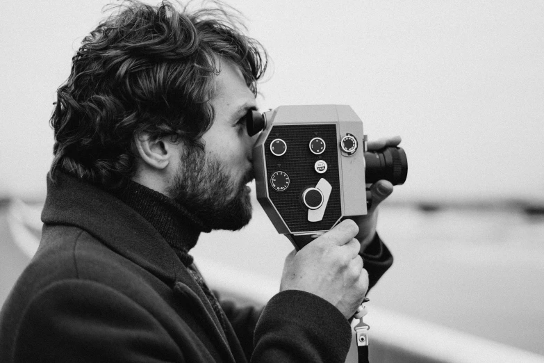 a black and white photo of a man holding a camera, by Etienne Delessert, unsplash, conceptual art, seventies cinestill, screenwriter, orelsan, profile picture