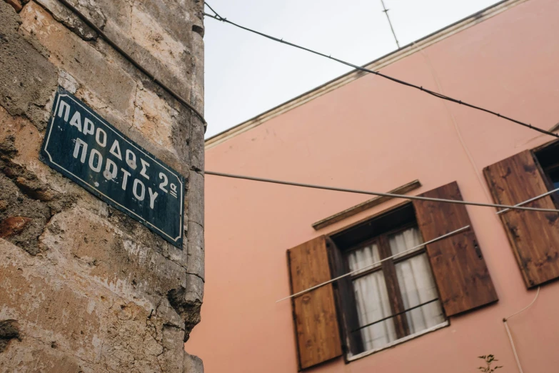 a street sign on the side of a building, inspired by Constantine Andreou, pexels contest winner, laputa, shady alleys, 🚿🗝📝