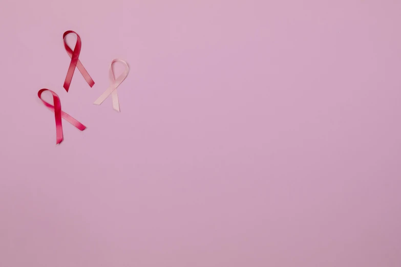a pair of pink ribbons on a pink background, by Carey Morris, trending on pexels, hurufiyya, tumors, panoramic shot, 4k', 256x256