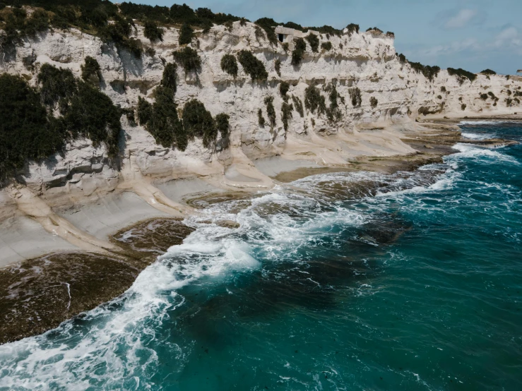 a large body of water next to a cliff, pexels contest winner, les nabis, apulia, erosion, manly, limestone